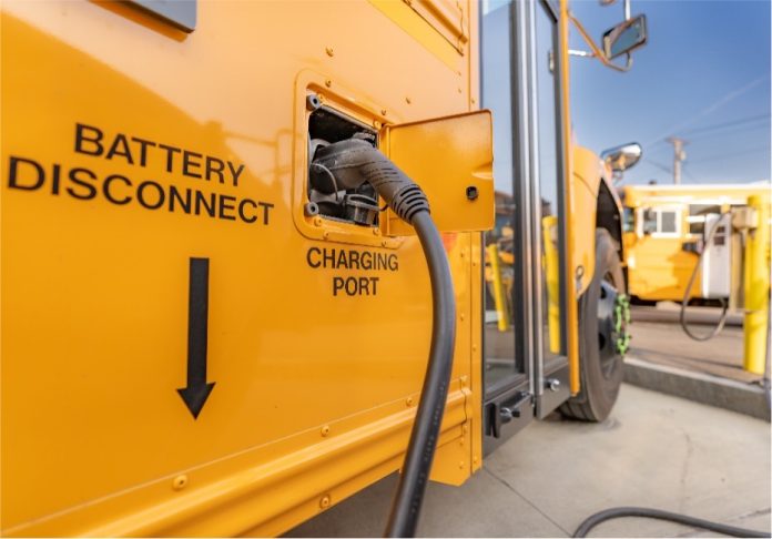 An electric school bus receives its charge.